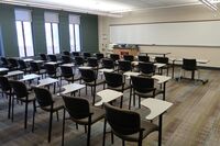 Front of room view with lectern on left in front of markerboard 