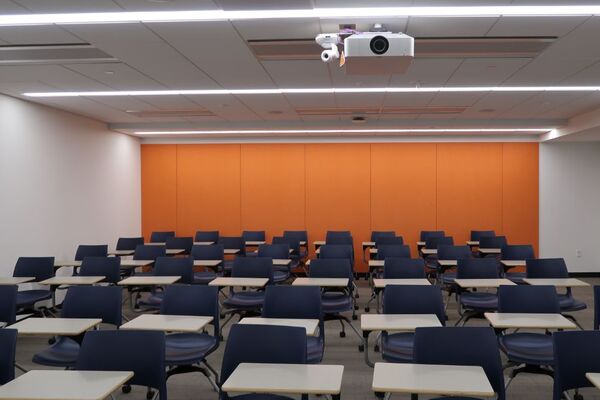 Rear of room view of student tablet arm chair seating on casters