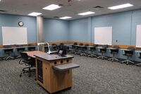 Back of room view of student tablet arm seating and markerboards on back wall