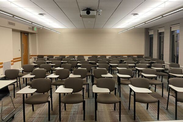 Back of room view of student tablet arm seating and exit door at rear left of room