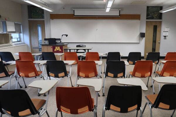 Front of room view with lectern on left in front of markerbaord and projection screen partially raised