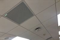 White 2¿ x 2¿ tile mounted in the ceiling to provide microphone coverage over student seating