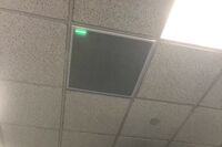 White 2¿ x 2¿ tile mounted in the ceiling to provide microphone coverage over student seating