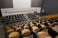 Front of room view with lectern on right in front of markerboard and projection screen above