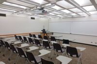 Front of room view with lectern on left in front of markerboard 