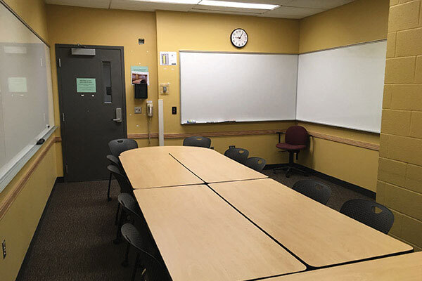 Photo of back of room from front of room with concrete pillar in center right of room.