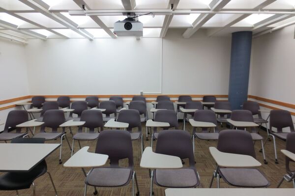 Rear of room view of student tablet arm chair seating on casters