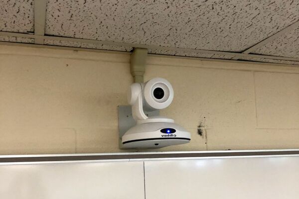 Camera mounted to a wall and instructor enabled adjustments to the lens to allow the instructor to be "seen" by the camera in more locations around the room