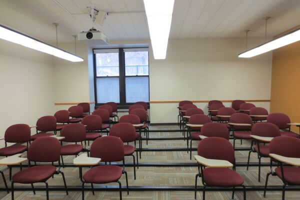 Rear of room view of student tablet arm chair seating on tiered floor surface