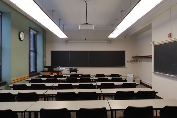 Front of room view with lectern on left side and projection screen fully raised