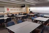 Front of room view with lectern on left in front of markerboard 