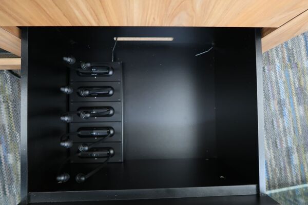 Pedestal - inside view of drawer showing assistive listening devices in charging base