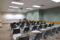 Front of room view with lectern on right in front of markerboard 