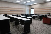 Back of room view of student tiered fixed-table and chair seating 