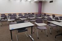 Rear of room view of student tablet arm chair seating on casters