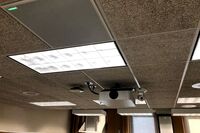 White 2¿ x 2¿ tile mounted in the ceiling to provide microphone coverage over student seating