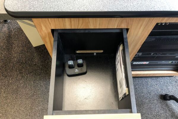 Pedestal - inside view of drawer showing two wireless mics in charging base