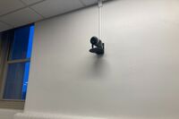 Camera mounted to a wall and instructor enabled adjustments to the lens to allow the instructor to be "seen" by the camera in more locations around the room