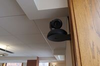 Camera mounted to a wall and instructor enabled adjustments to the lens to allow the instructor to be "seen" by the camera in more locations around the room