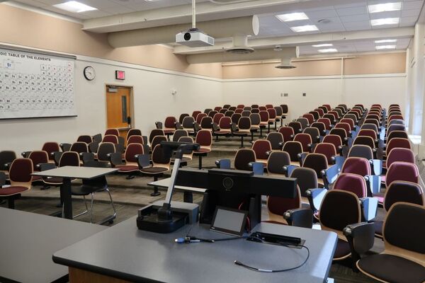 Back of room view of student auditorium seating and and exit door at left side of room