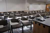 Back of room view of student tablet arm seating and exit door at right rear of room