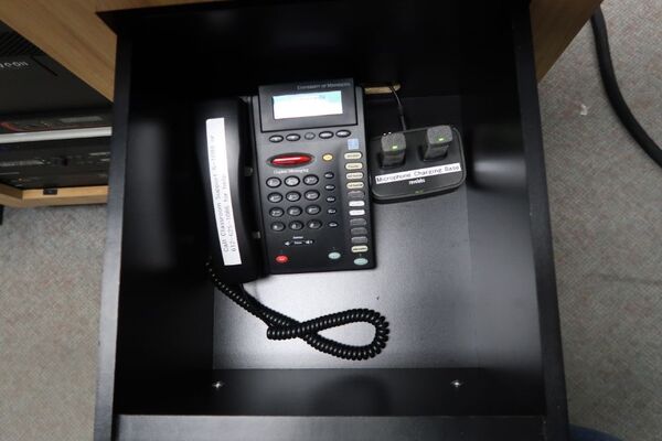 Pedestal - inside view of drawer showing two wireless mics in charging base, and telephone