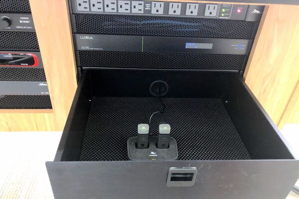 Pedestal - inside view of drawer showing two wireless mics in charging base