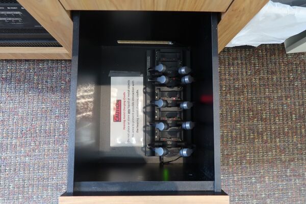 Pedestal - inside view of drawer showing assistive listening devices in charger