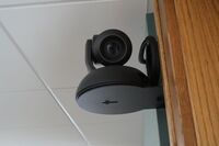 Camera mounted to a wall and instructor enabled adjustments to the lens to allow the instructor to be "seen" by the camera in more locations around the room